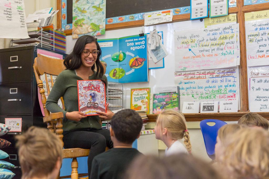 密歇根州立大学丹佛分校的学生伊达丽·努涅斯在教室里给孩子们读书.