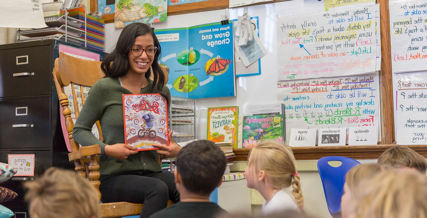 密歇根州立大学丹佛分校的学生伊达丽·努涅斯在教室里给孩子们读书.