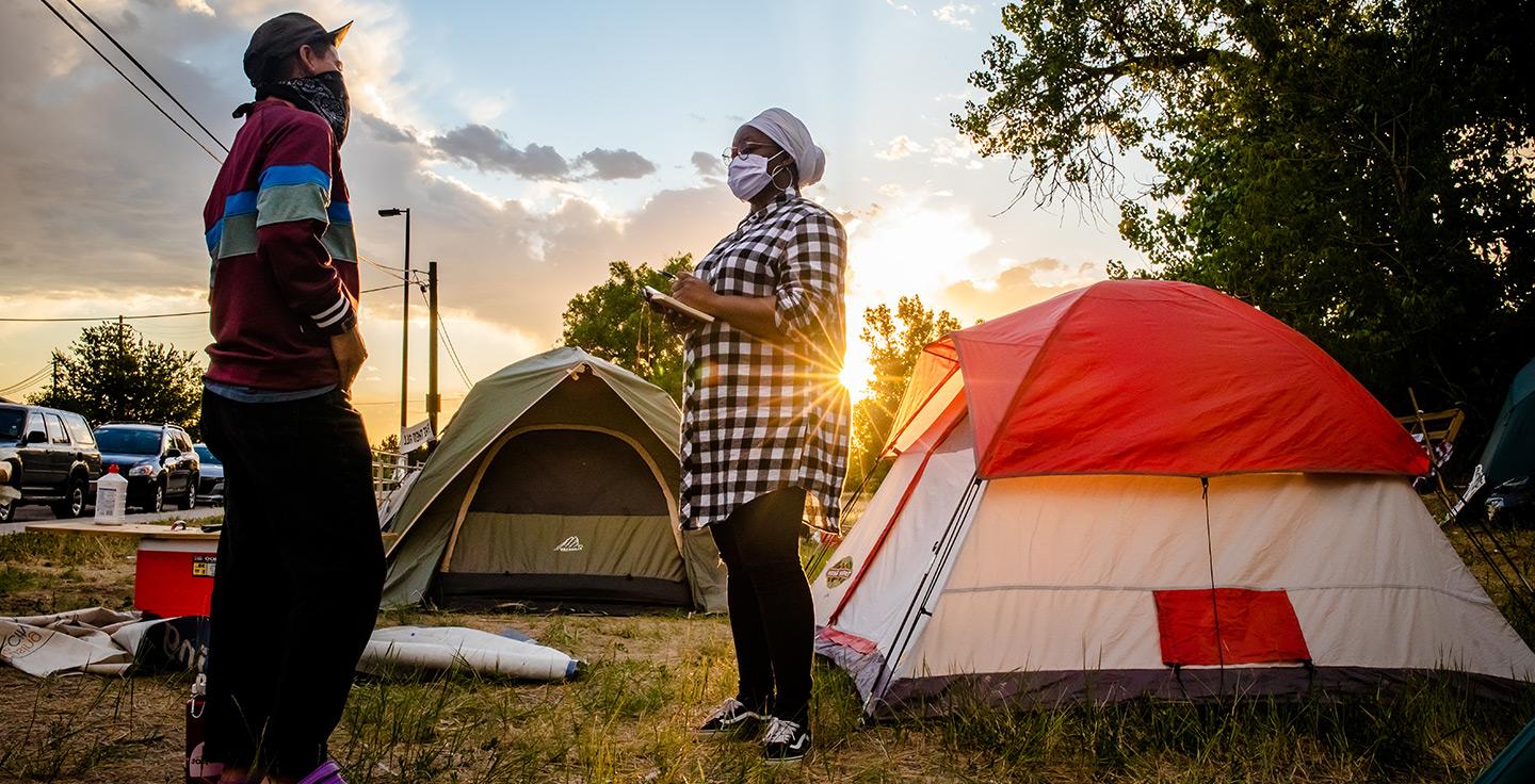 社会纪录片学生在一个无家可归者的营地进行采访