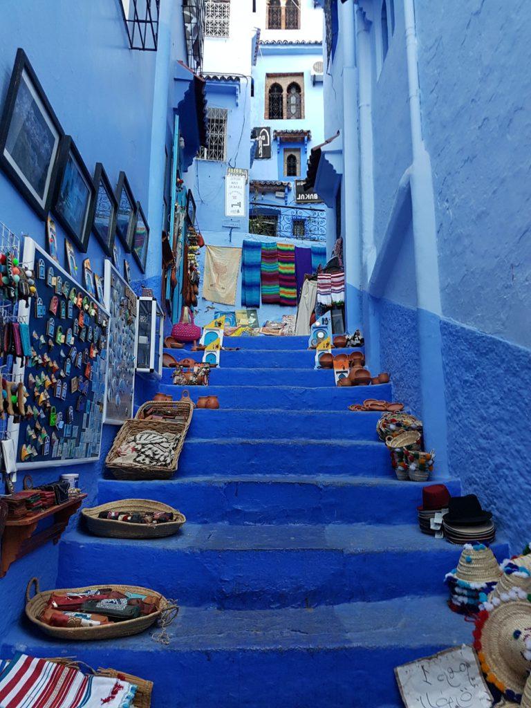 蓝色的楼梯上铺着装满手工制品的草编篮子