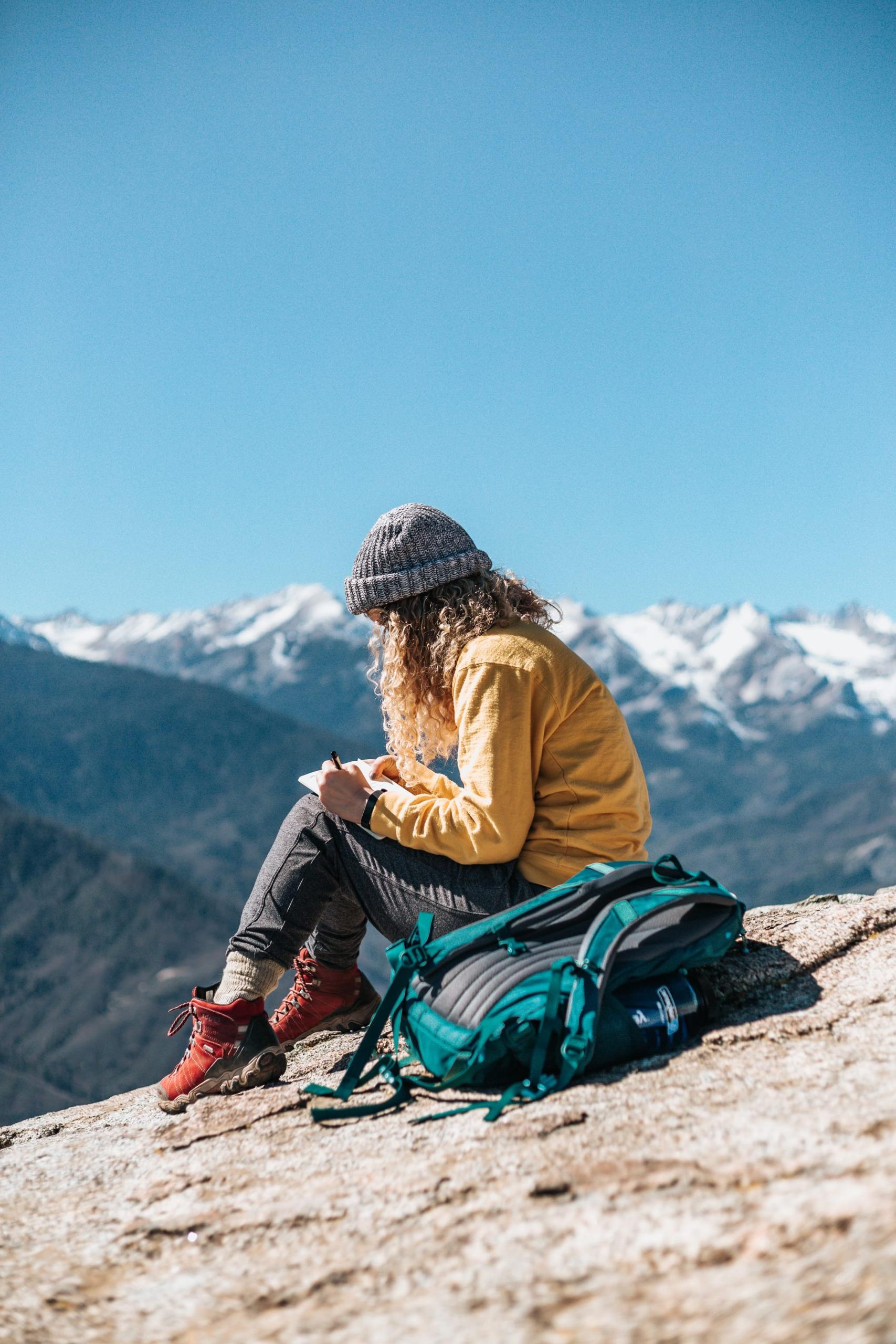 一张年轻女子坐在山里某处的照片