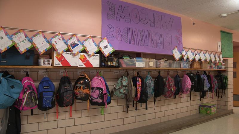 在一所小学的走廊上，背包挂在挂钩上.