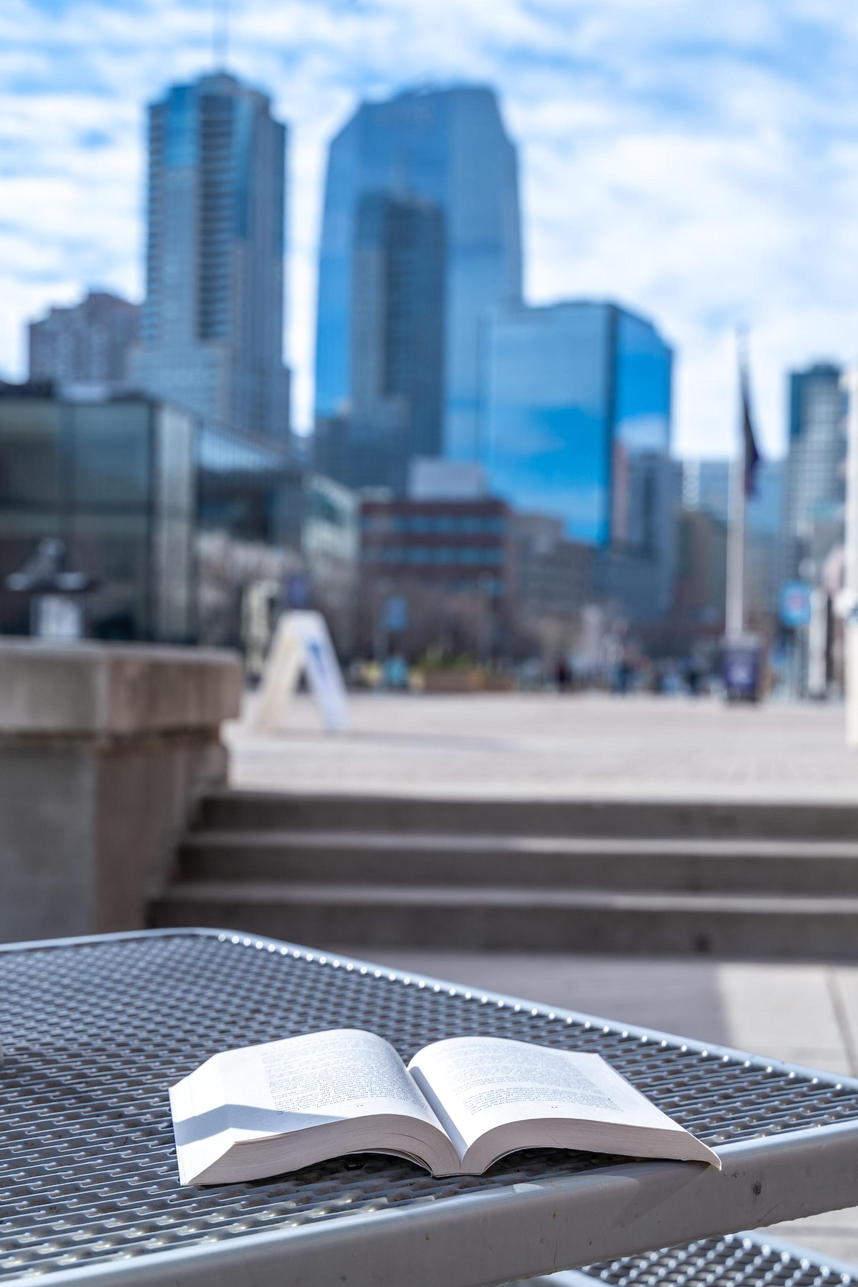 open book sitting on a table facing with downtown Denver in the background