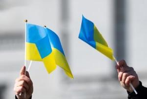 两只手挥舞着乌克兰国旗的特写.