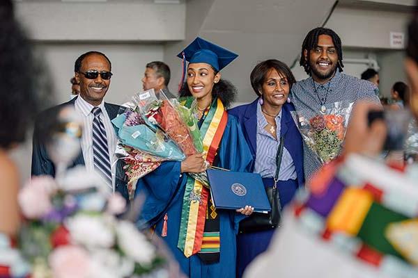 密歇根州立大学丹佛分校的毕业生和她的家人在毕业典礼上.