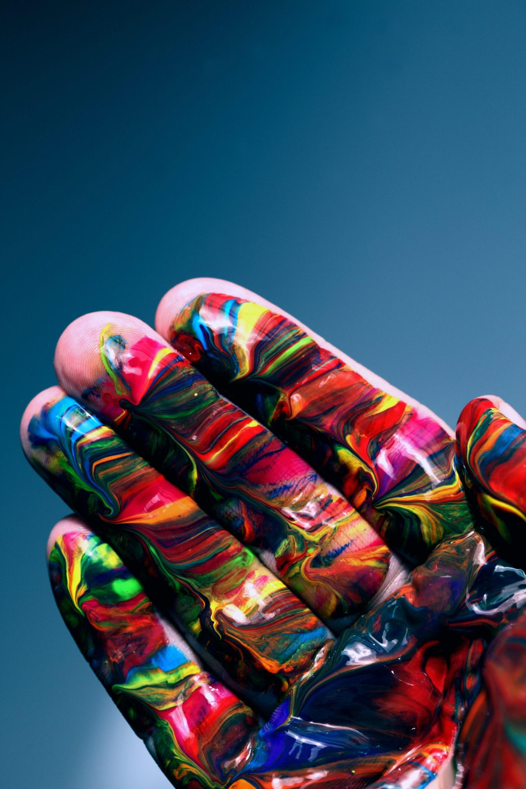 一只手指和手掌上涂满彩色颜料的手