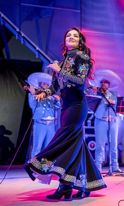 Lupita Infante performing on pink and purple stage