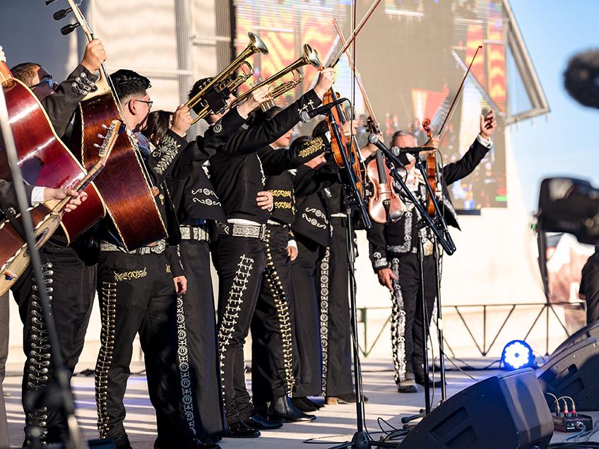 mariachi performers holding up their instruments in a line