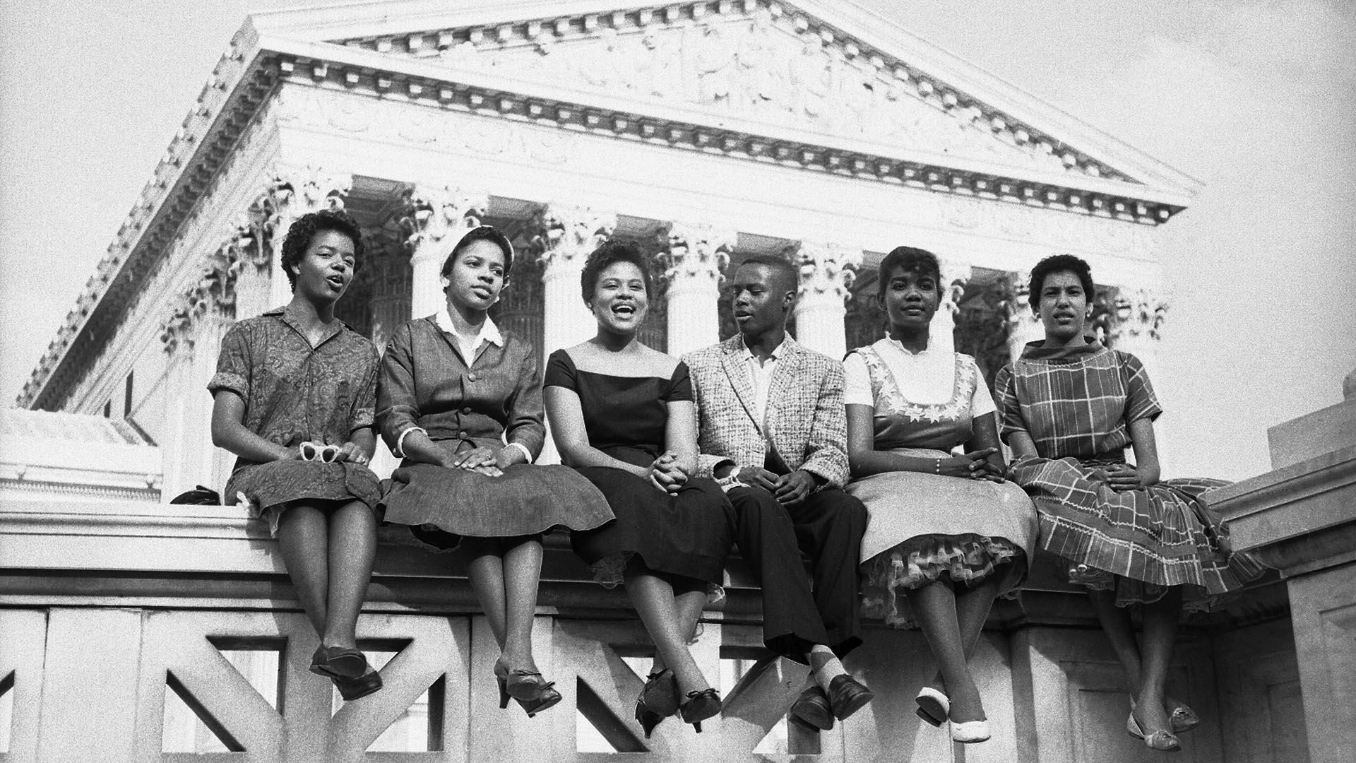 这张照片摄于1958年，当时就读于小石城中央高中的六个黑人孩子坐在最高法院外. 从左到右:卡洛塔墙, 15, 梅尔瓦Patillo, 16, 托马斯杰佛逊, 15, 米妮·简·布朗, 16, 格洛丽亚雷, 15, 伊丽莎白·埃德克福德, 16. 图片来源:Getty Images