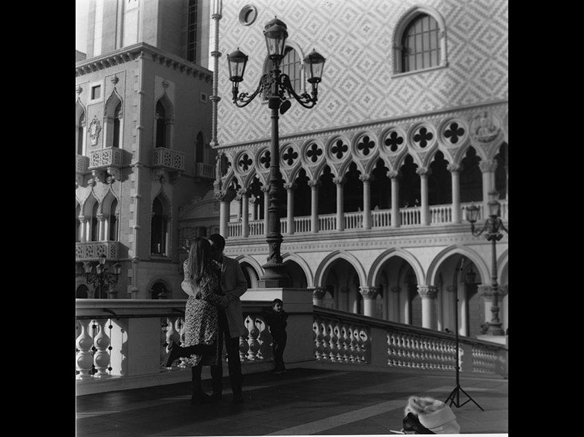 一对情侣在威尼斯式建筑前接吻.