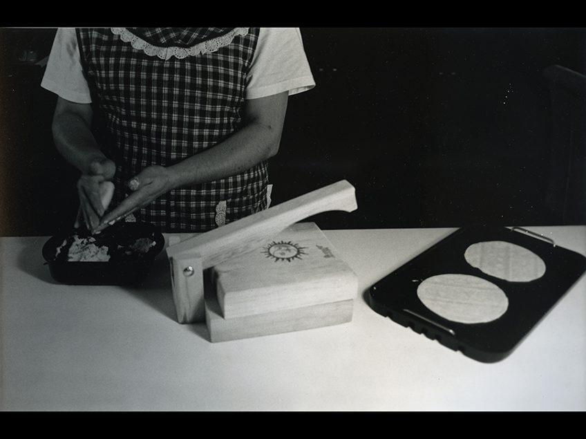 一个女人做玉米饼的黑白图像.