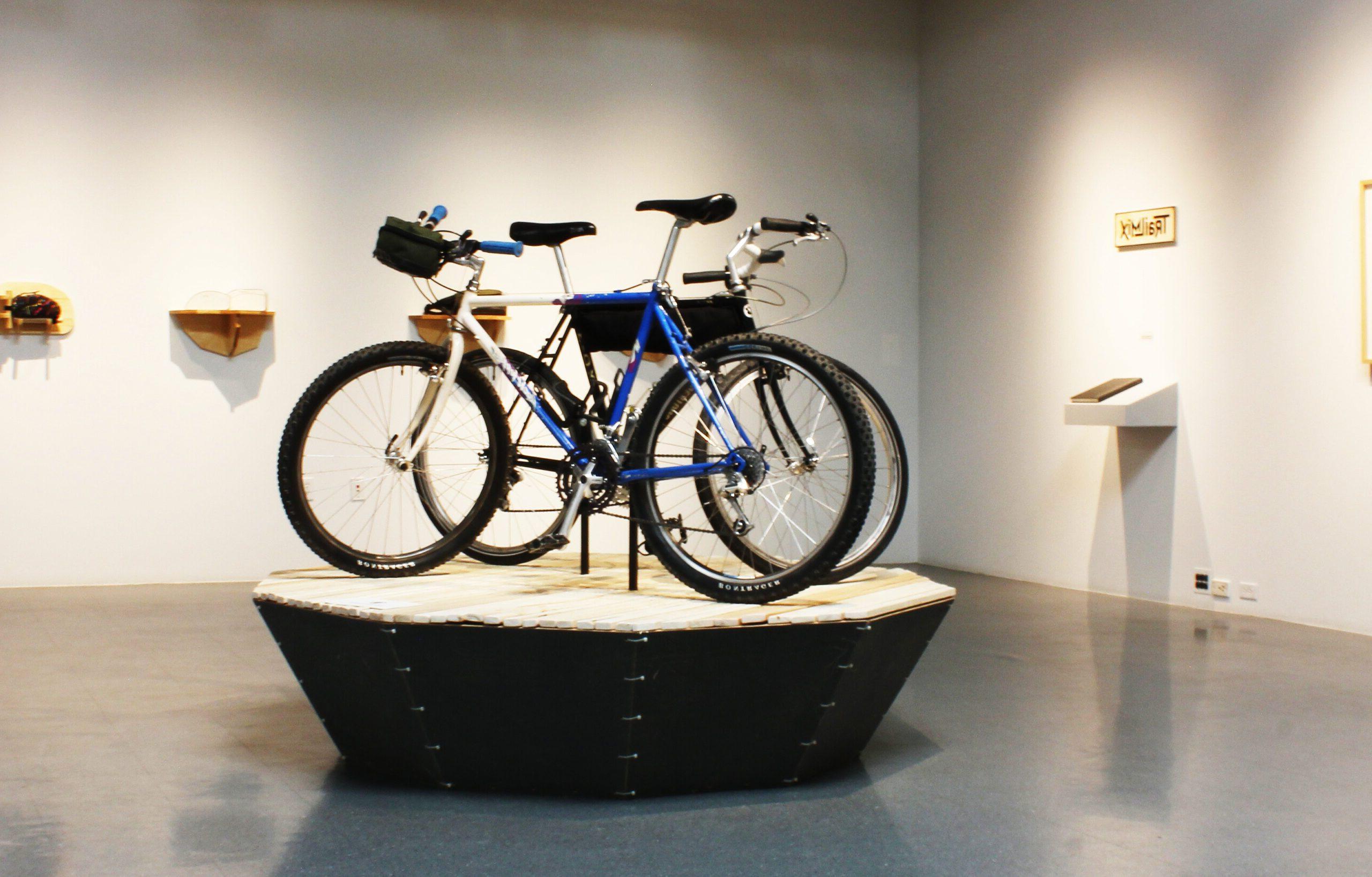 有高高的天花板的画廊空间，两辆配有齿轮的自行车.