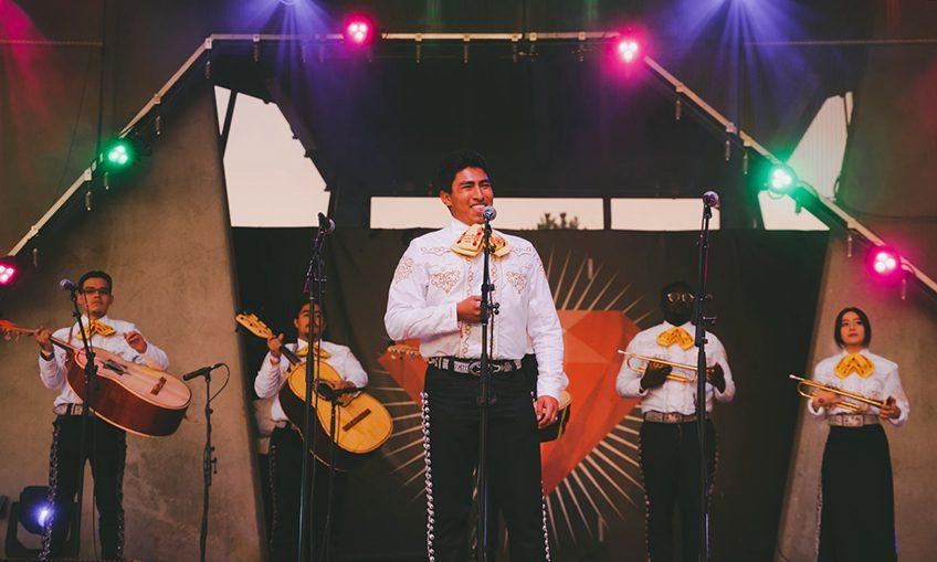 mariachi singer smiling in front of mariachi group