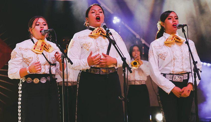 three female mariachi singers performing